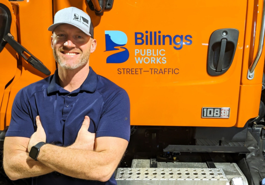 Jake Barnhart, our inaugural CDL Trainer, stands next to a Street Traffic truck