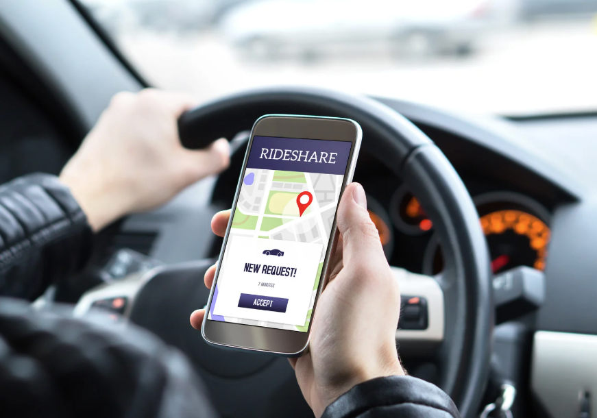 A hand holding a phone that shows a ride share request on the screen. 